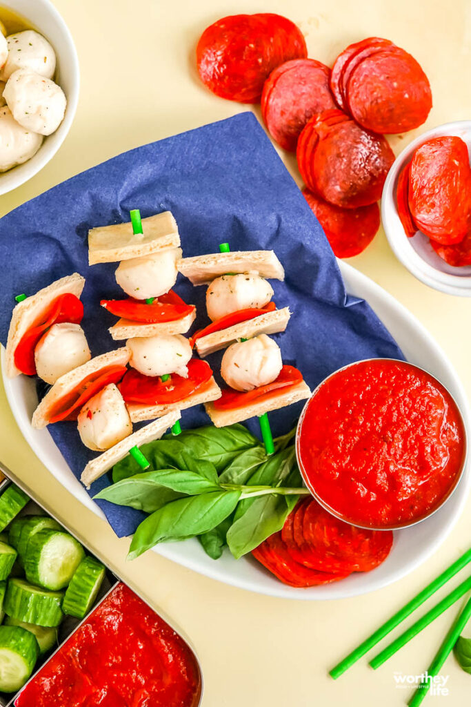 pizza kabobs in white platter with pizza sauce