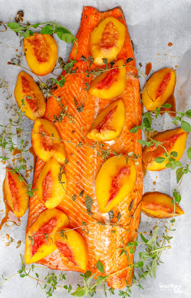 fresh salmon with peaches on baking sheet