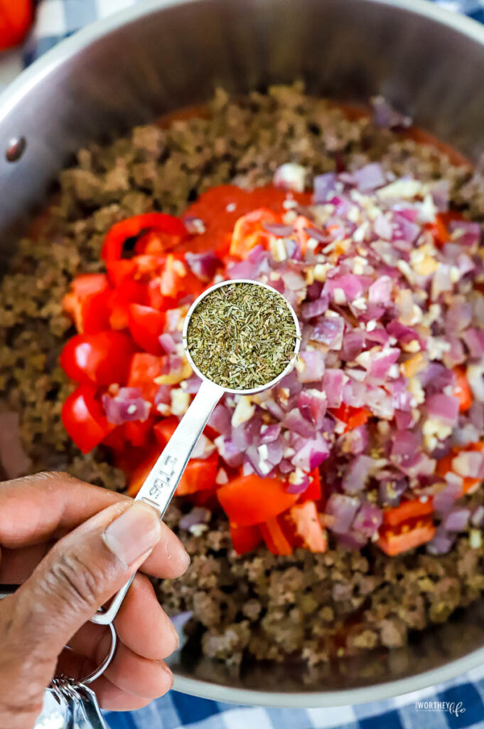 man putting seasonings in a large skillet