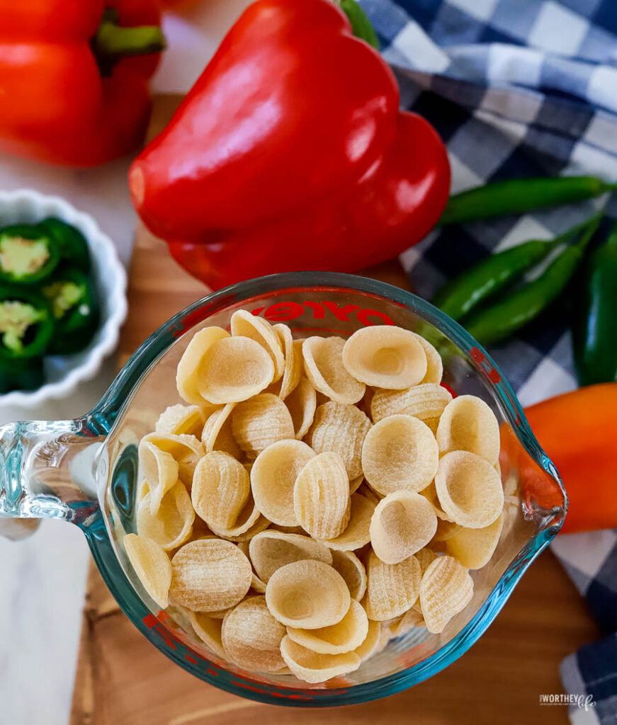 pasta in measuring cup with red peppers