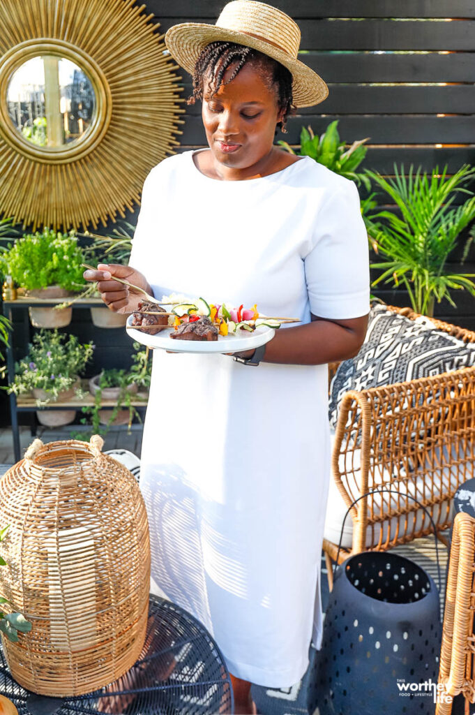 woman enjoying lamb asado in backyard