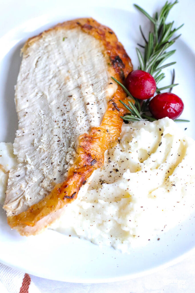 turkey sliced with mashed potatoes on white plate