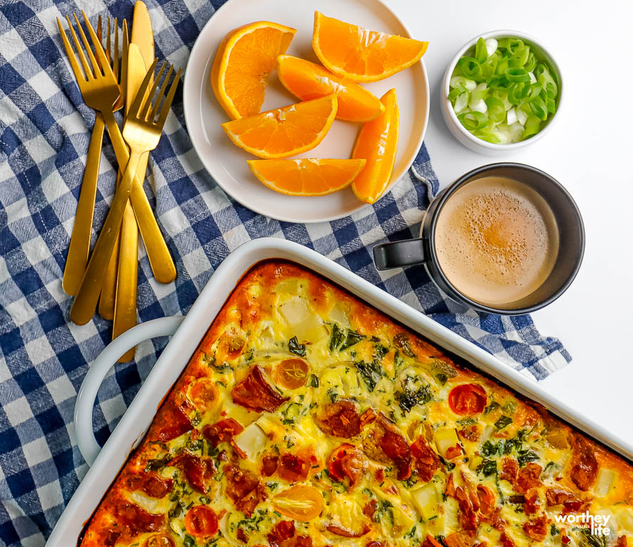 a table set for breakfast with a baked quiche, fruit, and coffee