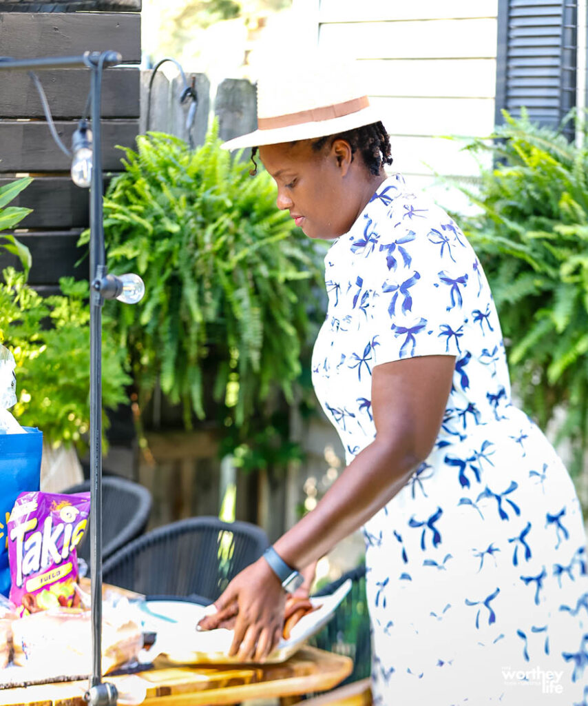 woman prepping table for outdoor family dinner night