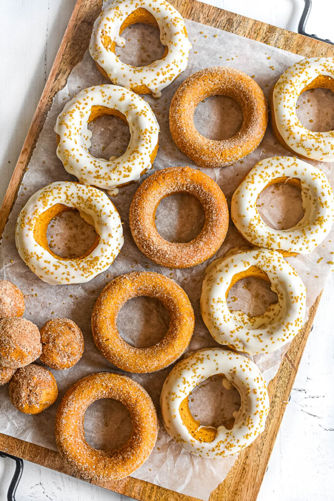pumpkin donut holes on baking sheet with doughnuts