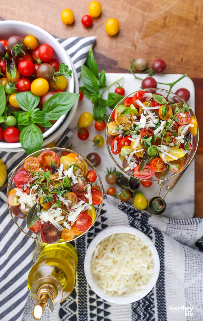 colorful tomato salad served in glassware, bowl of grated cheese