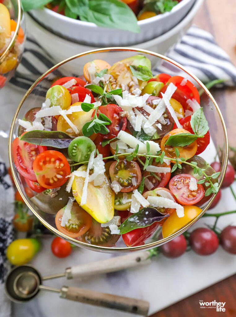 tri colored cherry tomato salad served in a glass topped with cheese