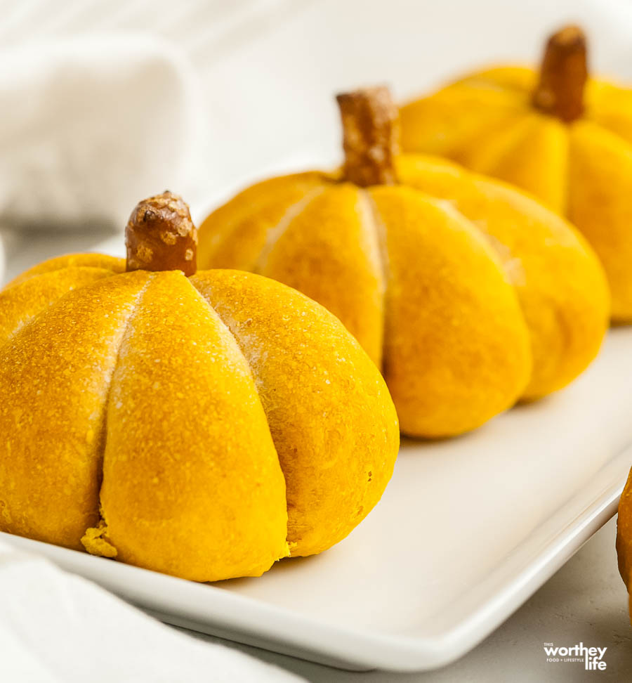 pumpkin shaped dinner rolls on white plate