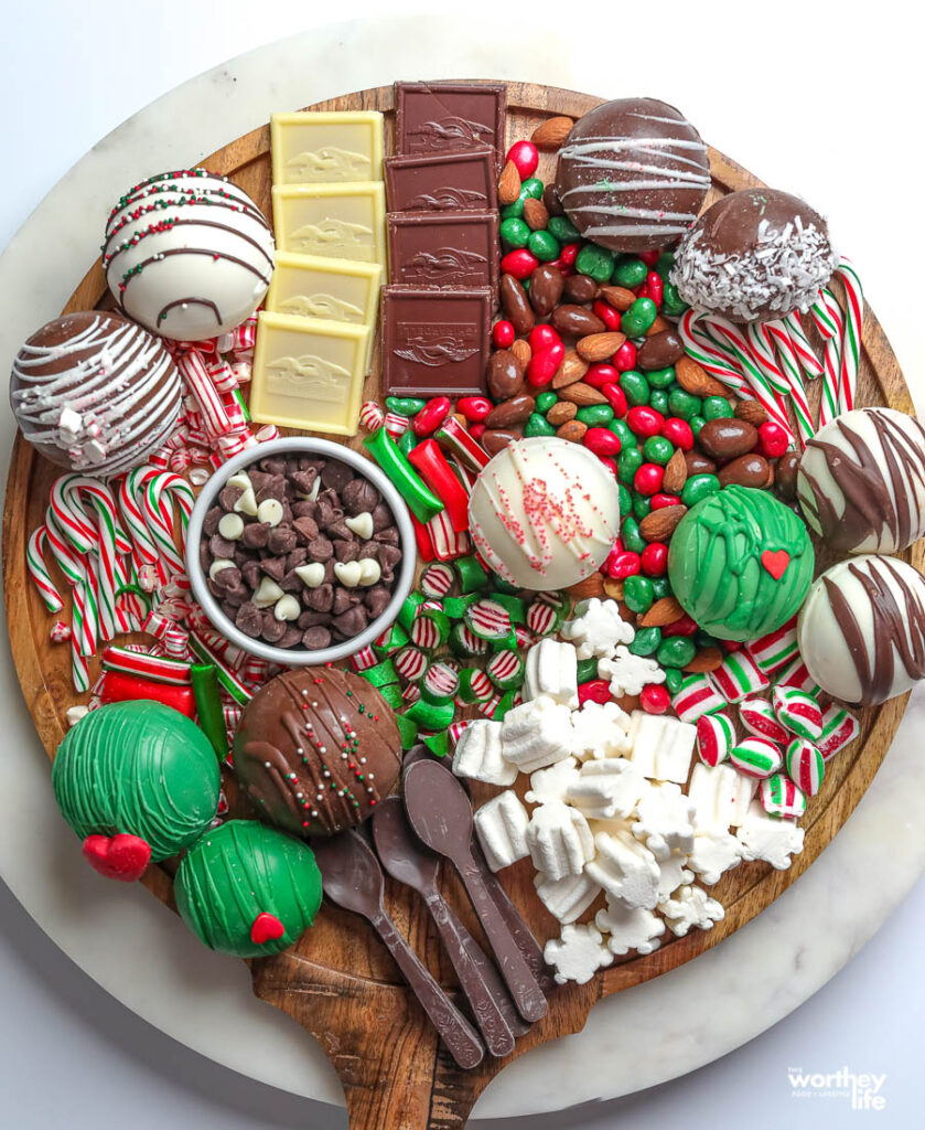 round grazing board filled with candy and hot cocoa bombs