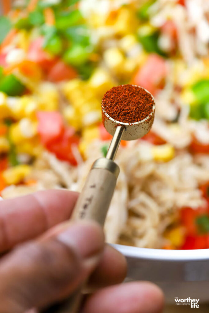 adding spices to a chicken casserole