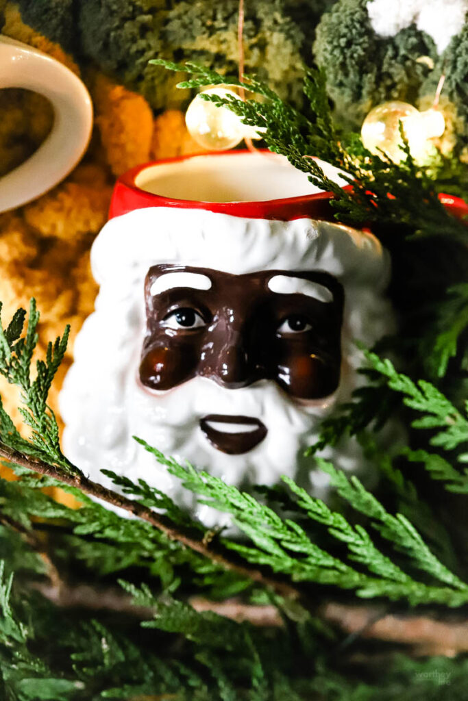 black santa mug on greenery