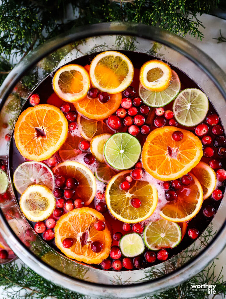 punch bowl filled with juice, lemon-lime soda and fresh sliced fruit