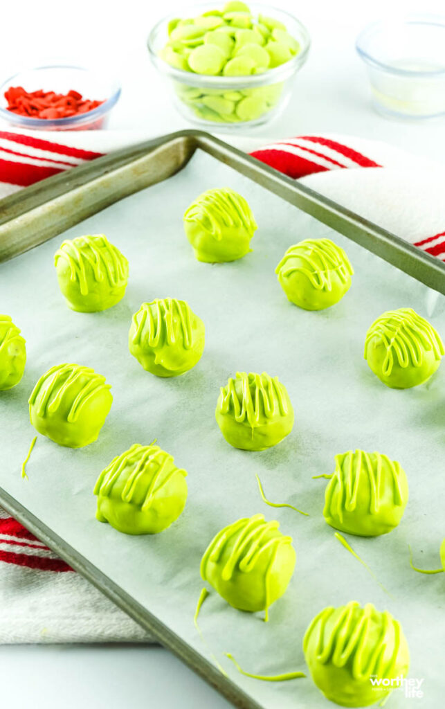 process of making grinch balls on baking sheet