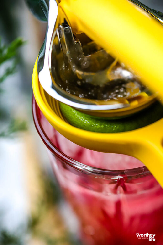 using a lemon squeezer to squeeze lime