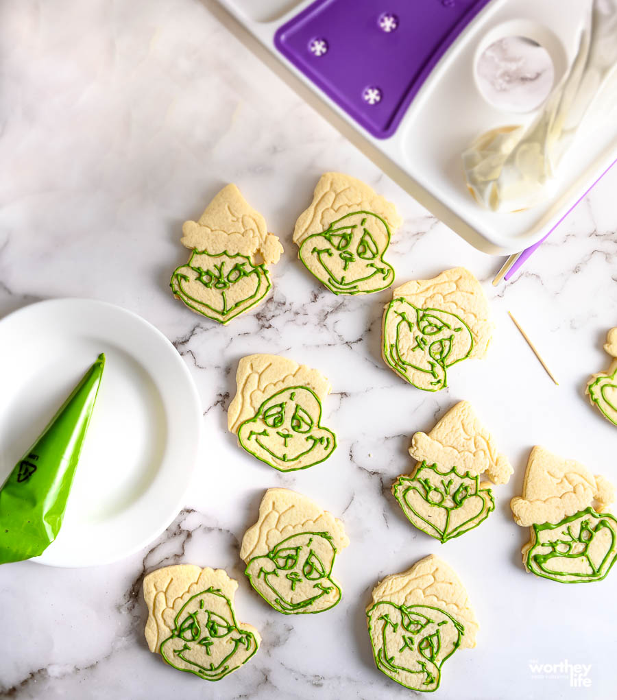 using green royal frosting to make a grinch face