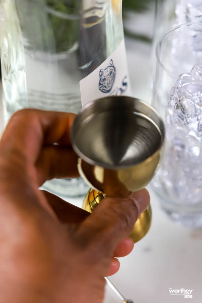 man's hand measuring tequila