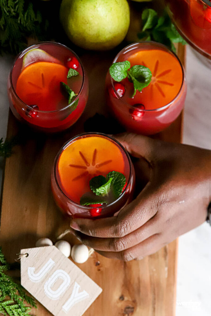 a hand grabbing a glass of holiday punch