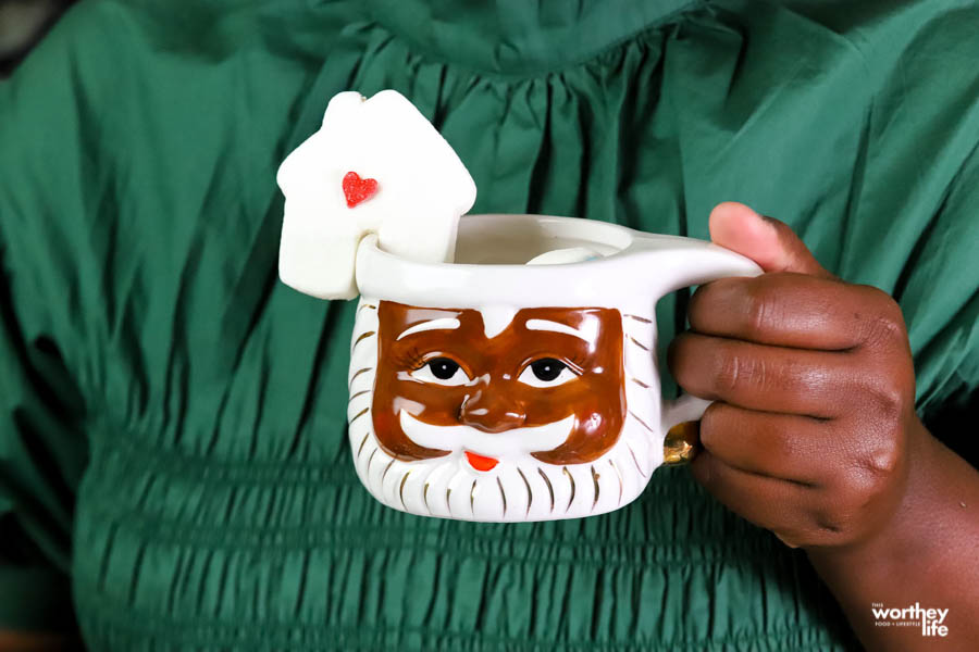 woman holding a black santa mug with marshmallow topper