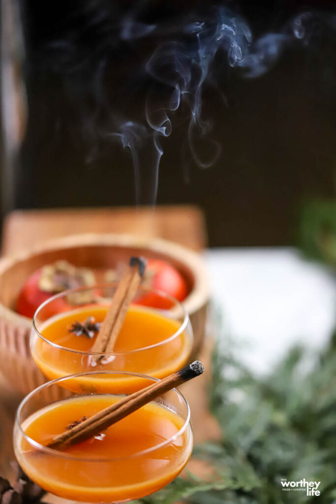 glasses of persimmon rye with smoky cinnamon sticks