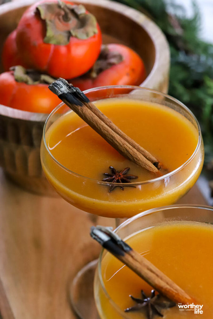 persimmon cocktails garnished with star anise and a cinnamon stick