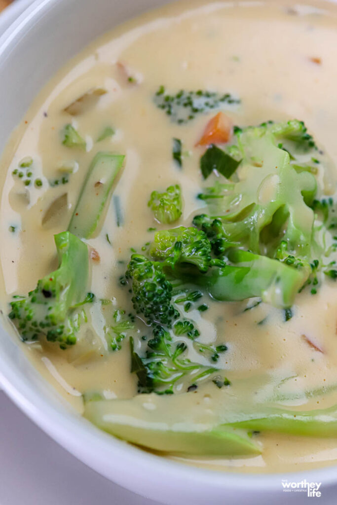 close up of a white soup bowl with warm broccoli cheddar soup