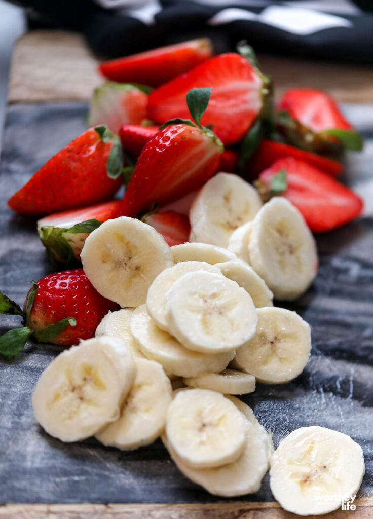 fresh strawberries and bananas on cutting board