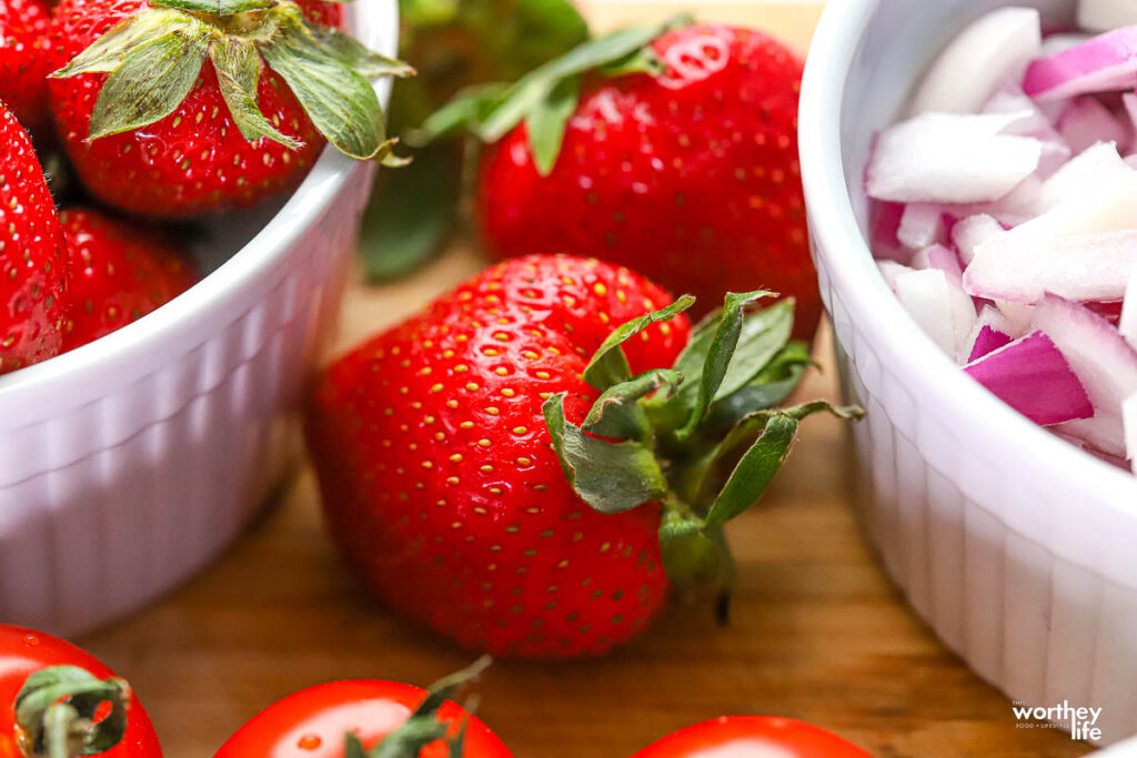 fresh strawberries in a bowl and on a cutting board