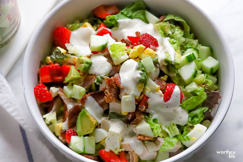 strawberry cobb salad in a white bowl