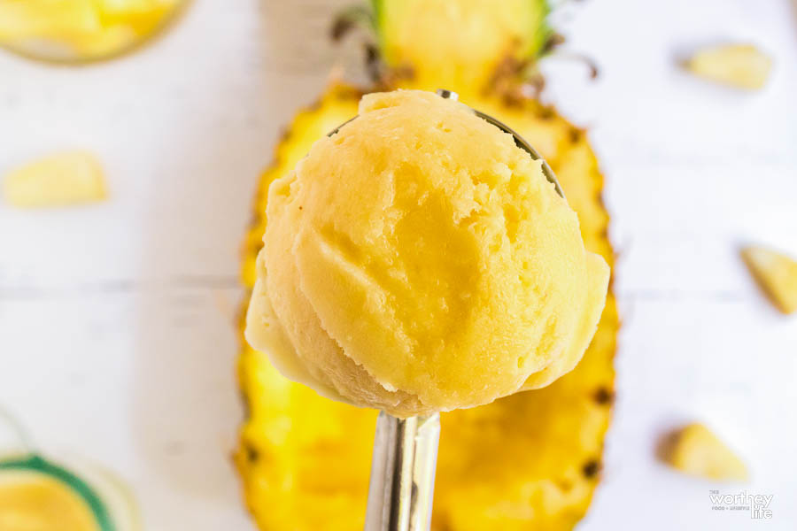 A scoop of fresh homemade pineapple ice cream on a spoon
