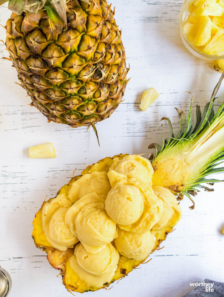 several scoops of homemade ice cream sitting in a hallowed pineapple