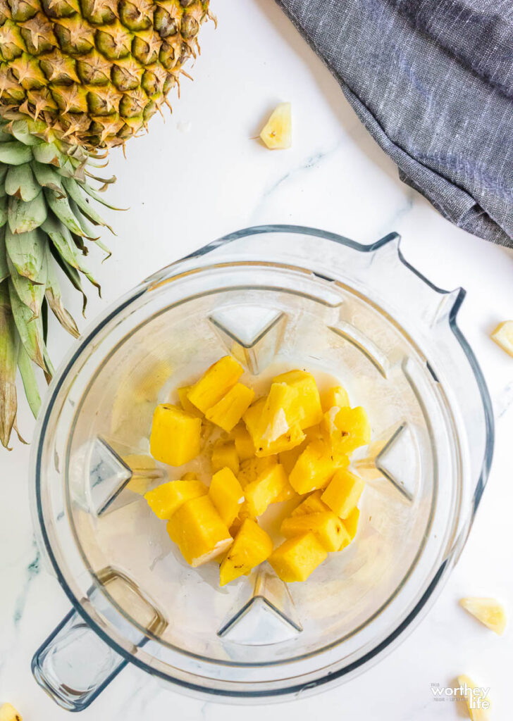 Putting pineapple chunk into a blender