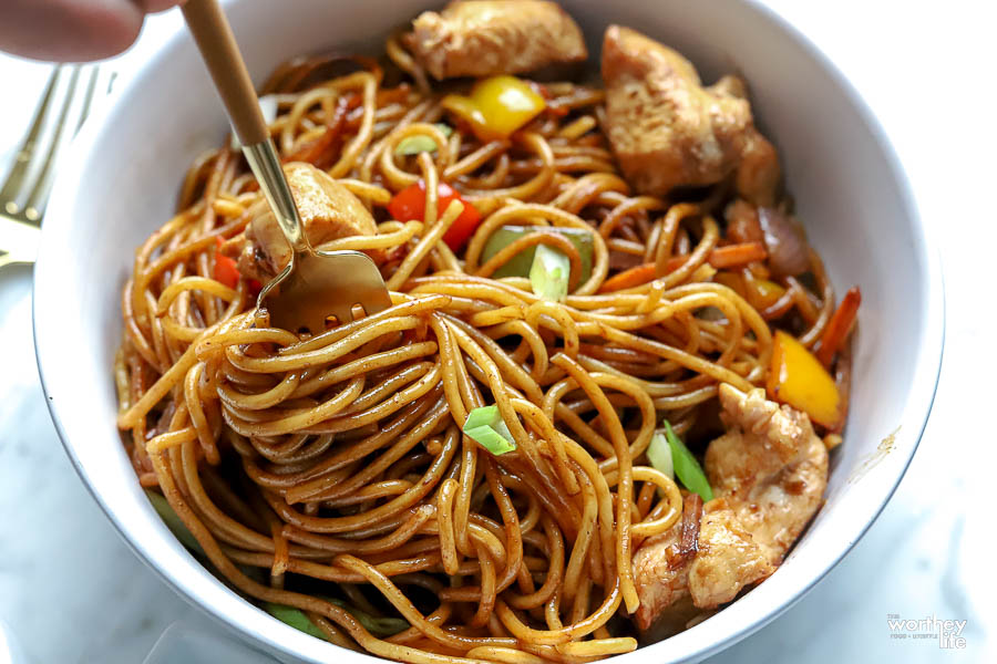 a fork twirling Chicken Lo Mein in a single white bowl