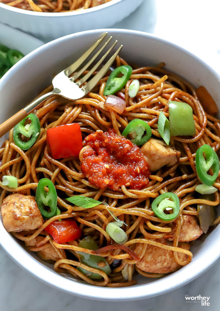 Homemade Chicken Lo Mein served in a white bowl with a fork