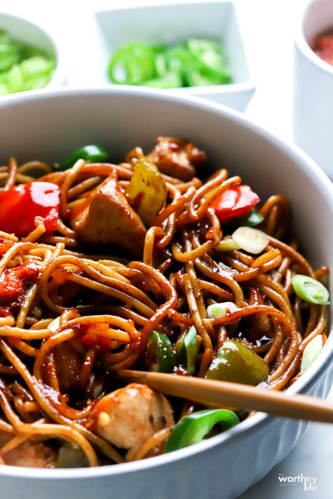 Chicken Lo Mein served with a white bowl with toppings on the side
