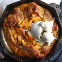 a peach galette with vanilla ice cream served in a cast iron dish