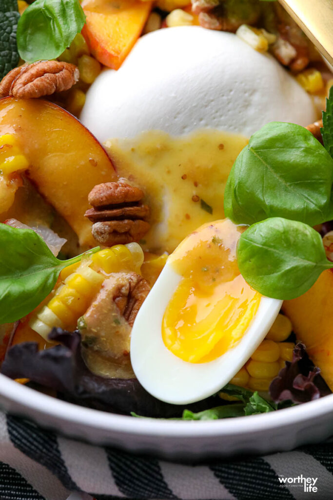 jammy eggs in bowl with salad ingredients