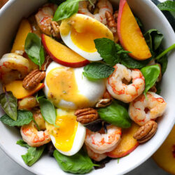 Our Peach & Buratta Shrimp Salad in a white serving bowl