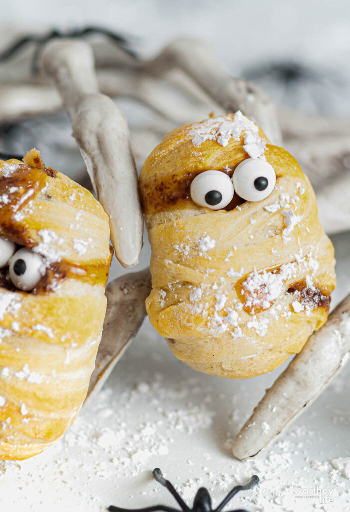 white skeleton holding a deep fried snickers mummy