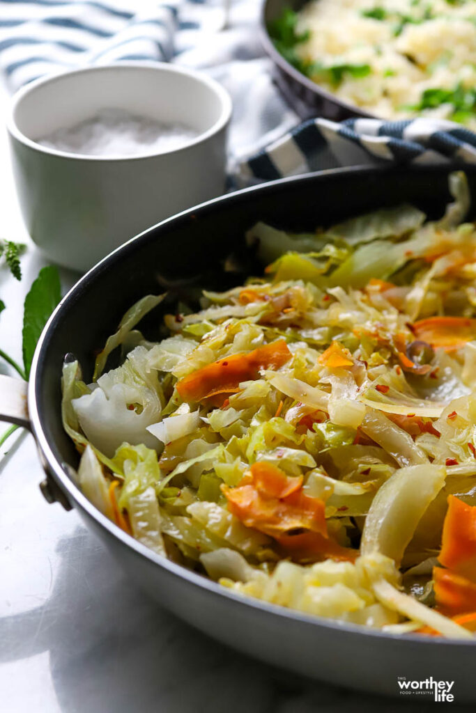 A table with a serving of fried cabbage and carrots.