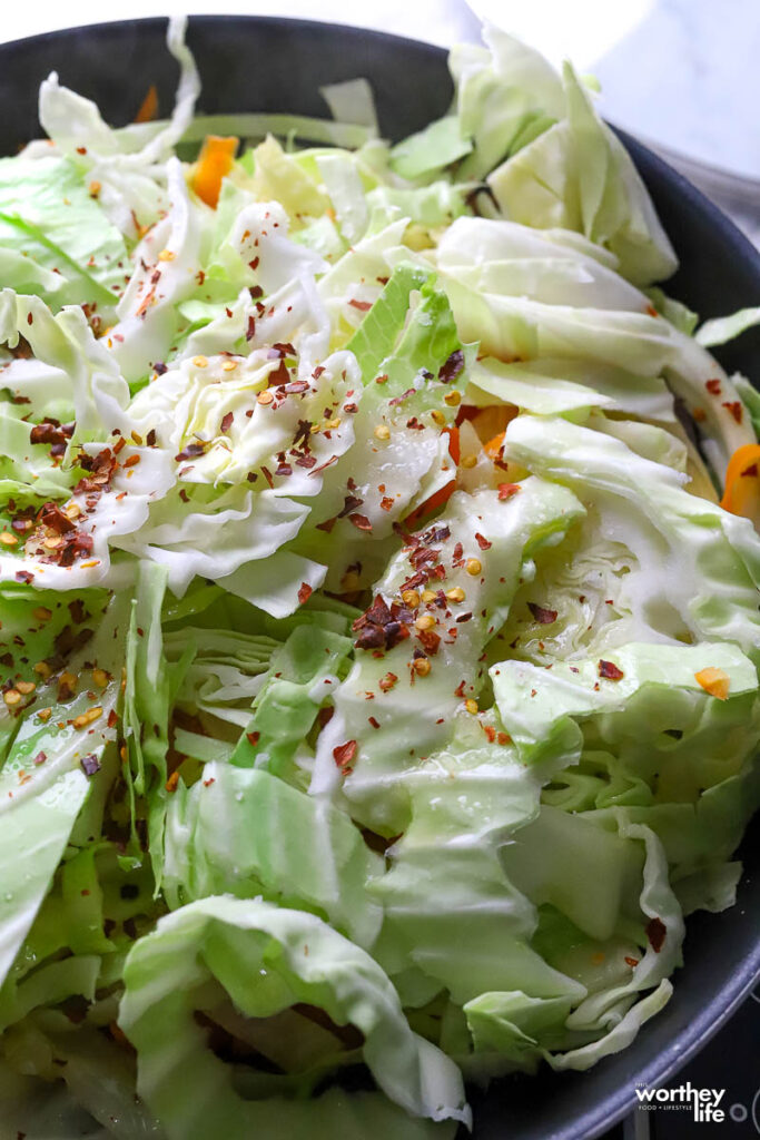 cut cabbage in a skillet seasoned with salt, black pepper, and red pepper flakes