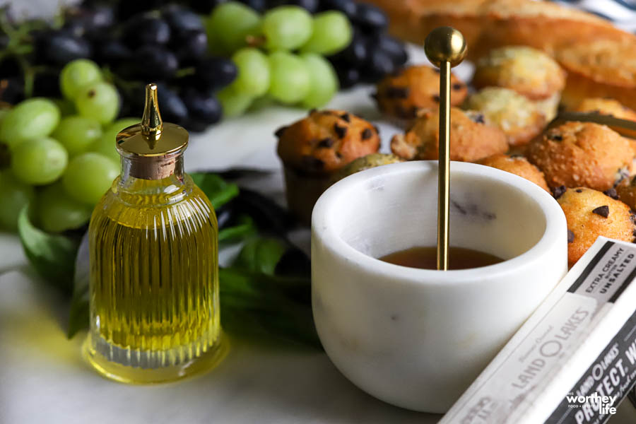olive oil, honey grapes on white board