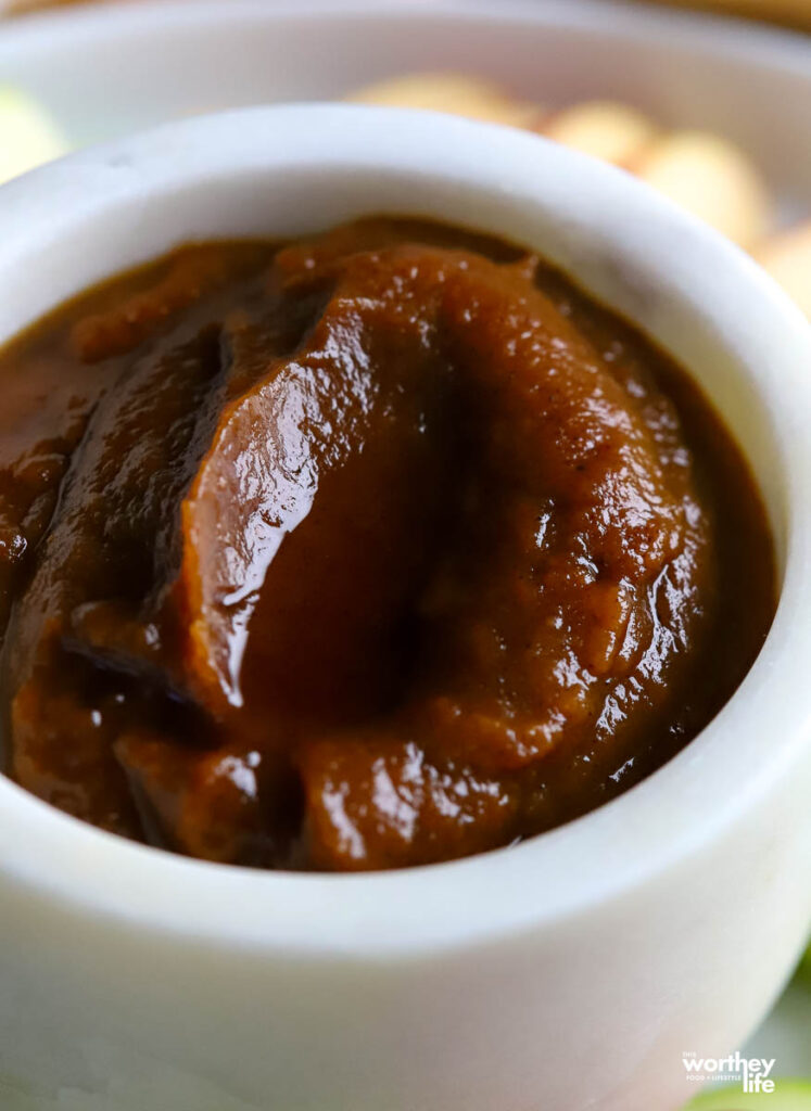 a white marble serving bowl filled with warm pumpkin butter