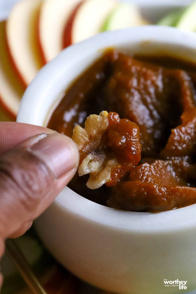 man dipping nut into pumpkin butter