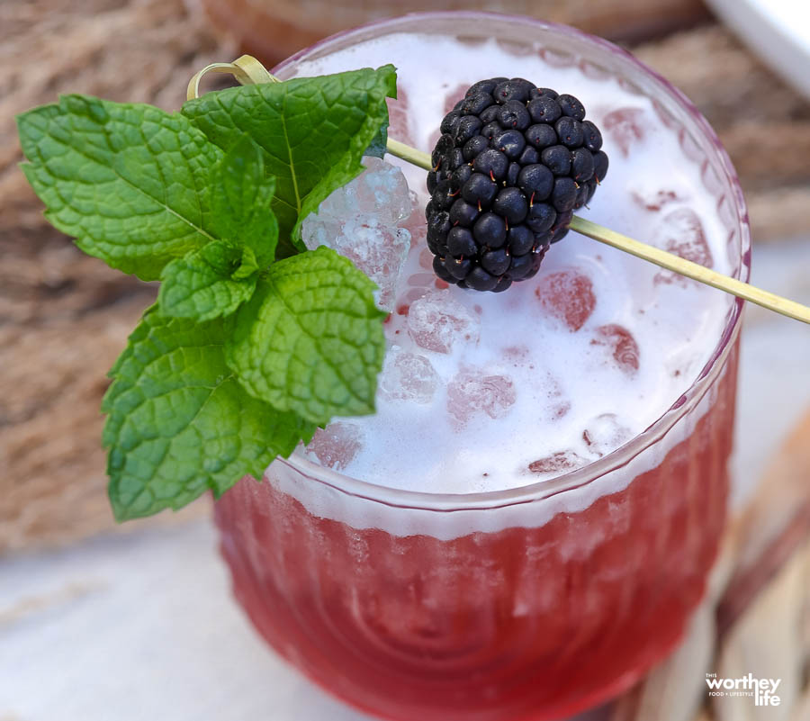 Our blackberry bourbon smash cocktail with fresh mint and a whole blackberry garnish. 