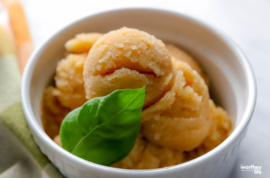 a white ramekin filled with apple pie sorbet and fresh basil