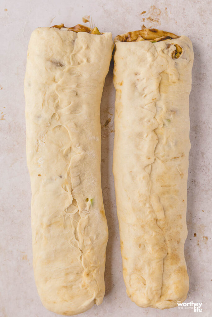 two pieces of rolled up dough for baking rolls