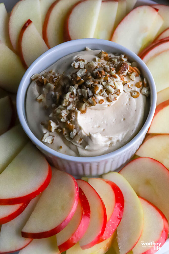 Cream Cheese Caramel Dip in a white ramekin with a spread of apples
