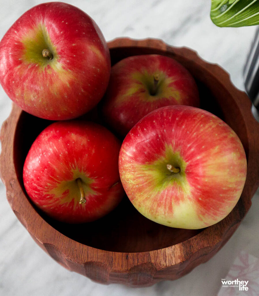 red delicious apples in a brown bowl