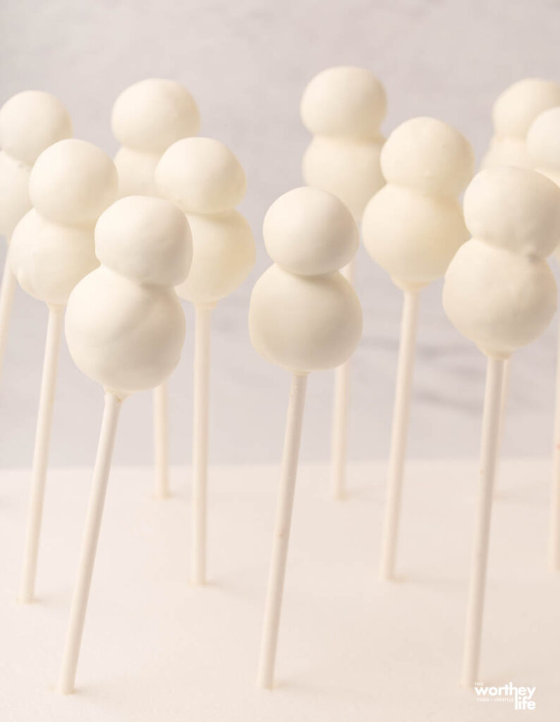 white cake balls standing up to dry