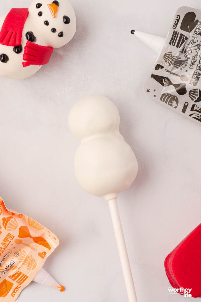 a blank snowman cake pop laying on a white flat surface